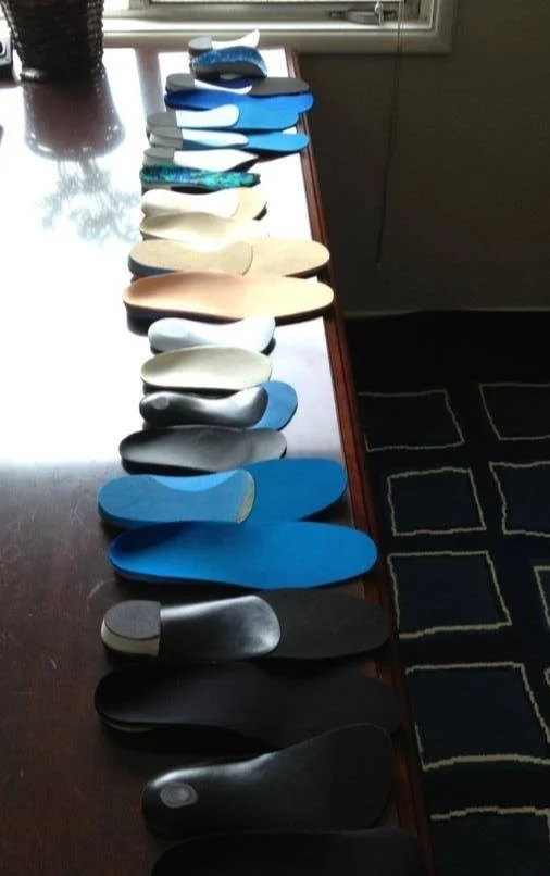 A variety of custom orthotics arranged on a table.